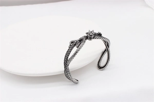 Detailed close-up of a vintage silver dragon bangle showing intricate scale textures