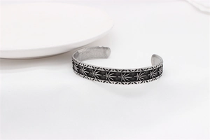 Detailed close-up of retro stainless steel leaf pattern on vintage open bangle for men