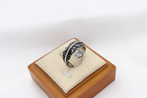 Macro shot of silver feather ring showing vintage oxidation texture and carved details