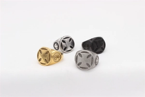 Detail of four vintage Maltese cross rings in gold, silver, matte and black finishes