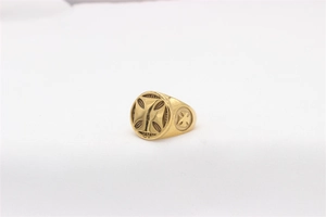 Macro detail of vintage gold signet ring featuring engraved Iron Cross and textured edges
