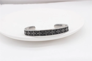 Detailed close-up of a silver vintage Viking Celtic knot pattern on a steel cuff bracelet