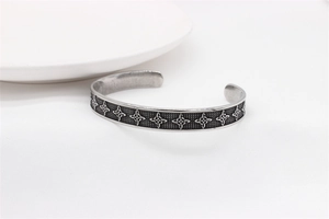 Macro detail of Nordic Viking Celtic knot pattern on silver steel cuff bracelet