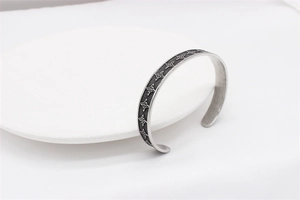 Close-up of vintage Celtic knot embossed patterns on silver stainless steel bangle