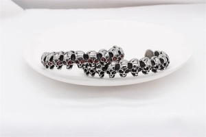 Detailed macro view of vintage skull bracelet with red zircon eyes and silver finish