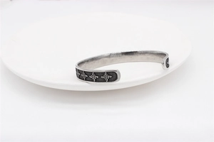 Close-up of Celtic knot relief patterns and textured finish on a silver steel cuff