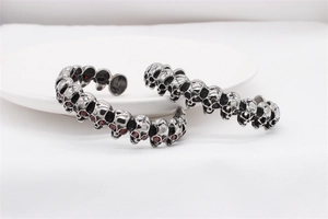 Detail of vintage skull bangles in stainless steel with red zircon eyes inlay