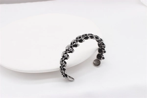 Detail shot of vintage silver skull bangle with interconnected punk style elements