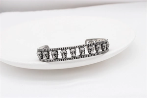 Detail of vintage silver skull punk bracelet with retro oxidized finish and studded edges
