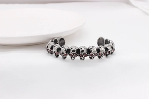 Detail of vintage skull bracelet in stainless steel with red rhinestone eyes for men
