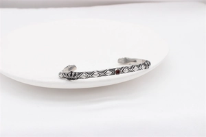 Detailed macro view of vintage stainless steel crown bracelet with a red gemstone inset