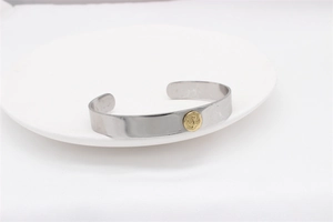 Detailed view of silver eagle ring with gold emblem on white ceramic display