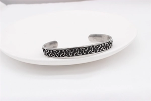 Detail of vintage silver cuff with Celtic Triquetra knots and engraved knotwork texture