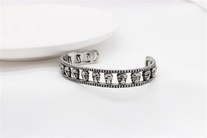 Detail shot of vintage skull cuff bracelet with distressed black finish and bead edges
