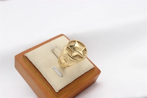 Detailed view of vintage gold star signet ring with radial texture and punk style engravings