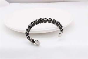 Detailed macro shot of gothic skull bracelet with red garnets and vintage metal texture