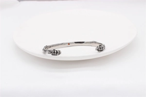 Macro detail of retro silver steel crown cuff bracelet with red gemstone accent