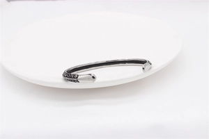 Detailed close-up of retro silver stainless steel bangle with ornate relief patterns