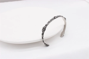 Detailed macro view of retro crown engraving on stainless steel bracelet with red stone