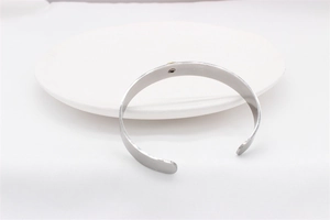 Detail view of a vintage eagle cuff bracelet with a golden inlay on a white ceramic plate