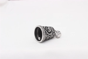 Detailed close-up of retro silver bell pendant with skull and vine patterns