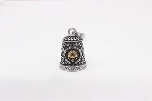 Close-up of a punk style bell pendant featuring a gold skull and gothic engravings