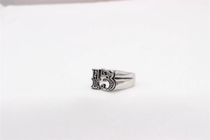 Dettaglio macro di un anello retrò in acciaio inossidabile con rilievo del numero 13