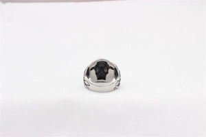 Macro shot of retro men's steel skull ring featuring intricate vintage gothic relief details