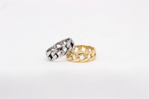 Close-up of polished gold and silver Cuban link chain rings in stainless steel