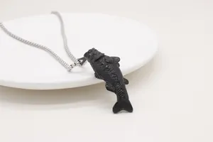 Detailed close-up of a matte black koi fish pendant on a silver stainless steel chain