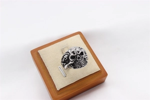 Macro view of vintage silver skull ring showing detailed punk carvings and aged finish