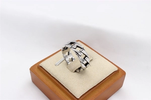 Macro detail of men's stainless steel chain ring with vintage oxidized finish on wood stand