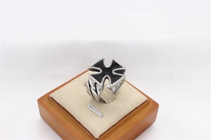 Macro shot of retro stainless steel cross ring on velvet stand with geometric details