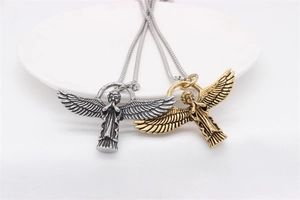 Detailed close-up of gold and silver vintage angel pendants with feathered wings on chains