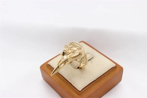 Detailed macro view of golden bird skull ring with intricate Celtic knot engraving patterns