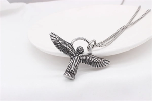 Detailed close-up of retro silver angel wing pendant on a classic square box chain