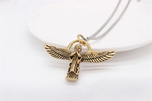 Macro shot of gold Cupid angel pendant with detailed wings and vintage blackened finish