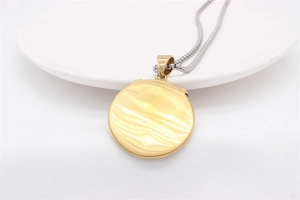 Detail of round gold pendant with brushed ripple texture on a silver box chain