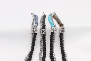 Detail of beaded cross bracelets with matte onyx, turquoise, and tiger eye stones