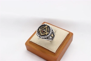 Close-up of vintage Freemason ring with red stone and gold compass emblem on silver band
