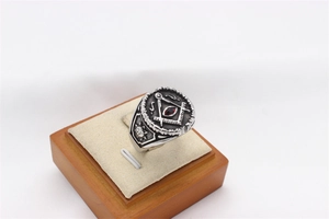 Macro shot of Freemason steel ring featuring a red gemstone and square and compass symbol