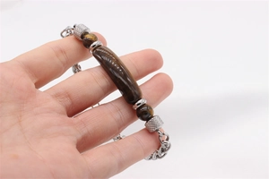 Detail view of tiger eye stone beads and braided titanium steel chain on a men's bracelet