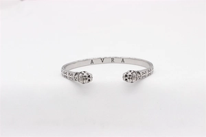 Detailed macro view of vintage tiger head cuff with engraved scrollwork and AVRA logo