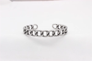 Gros plan sur un bracelet jonc ouvert en chaîne cubaine argentée au style vintage