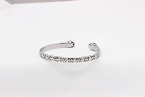 Detailed view of silver tiger head cuff bracelet with vintage wave pattern engraving