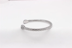 Macro detail of silver snake cuff bracelet showing intricate scale texture and retro style