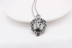 Detailed relief of vintage lion head pendant in silver finish on white ceramic