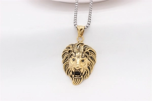Detail of a golden lion head pendant featuring fine textures and a silver box chain