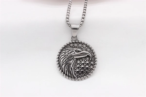Detailed close-up of eagle head relief pendant with textured geometric background and chain