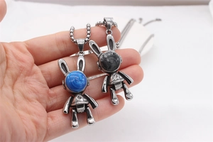 Gros plan de pendentifs lapin rétro avec détails robotiques en émail bleu et gris